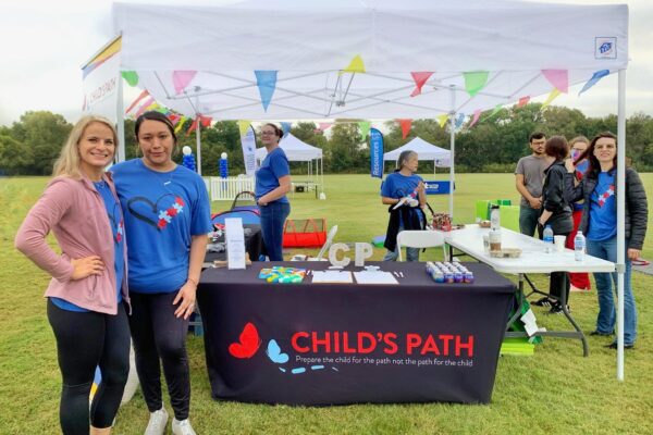 Volunteers at a Child's Path booth during an outdoor event.