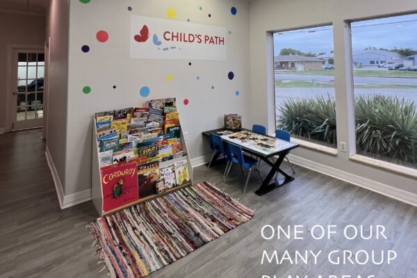 Colorful kids' play area with books and toys by a sunny window.