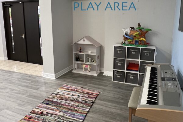 A cozy group play area with toys, a piano, and a colorful rug.