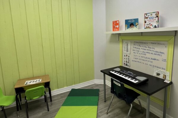 A small classroom corner with a keyboard, colorful blocks, and children's books.