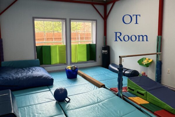 A colorful occupational therapy room with mats and equipment for kids.