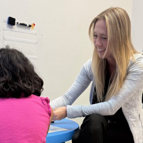 A woman comforting a child at a small table.
