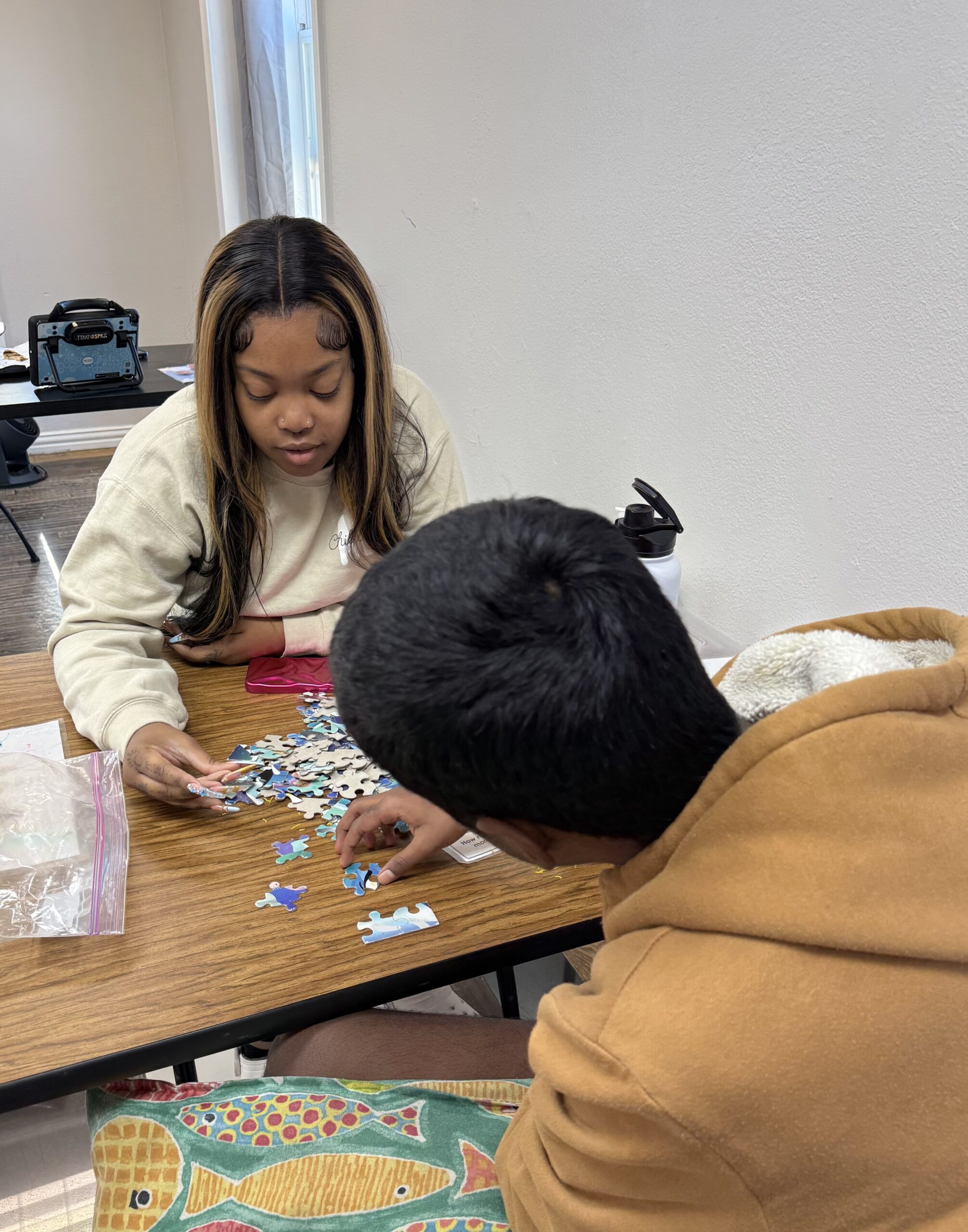 Two people assembling a jigsaw puzzle together.