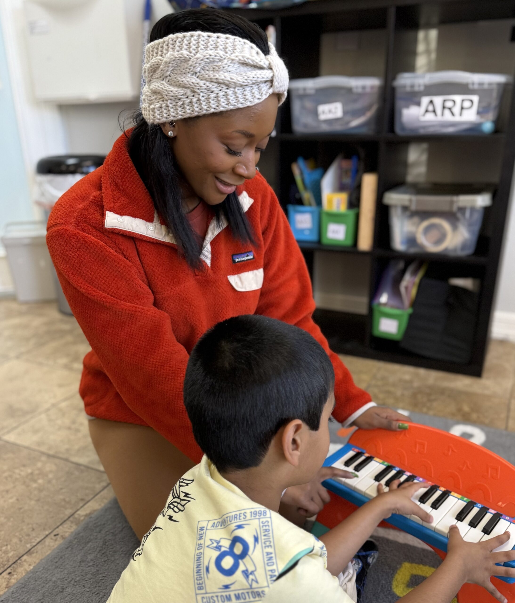 Adult and child playing a toy piano.