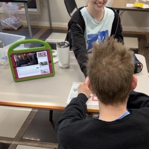 Two people interacting with a tablet device.