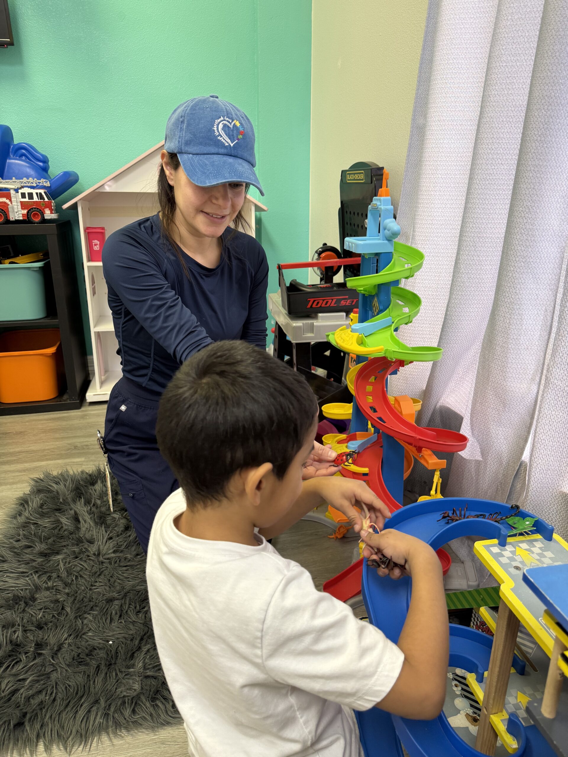 Child and adult playing with colorful toy track.