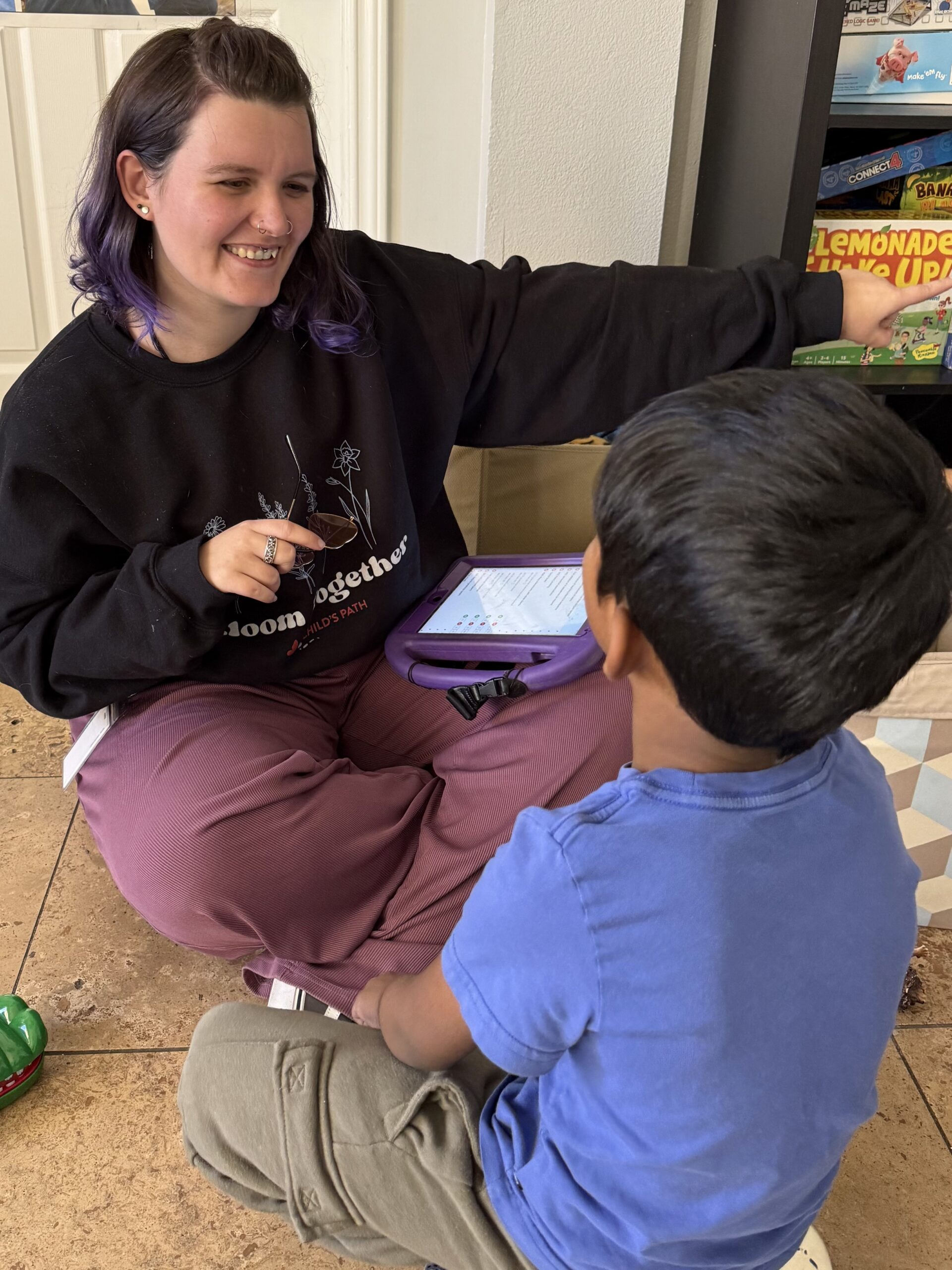 Woman interacting with child using a tablet.