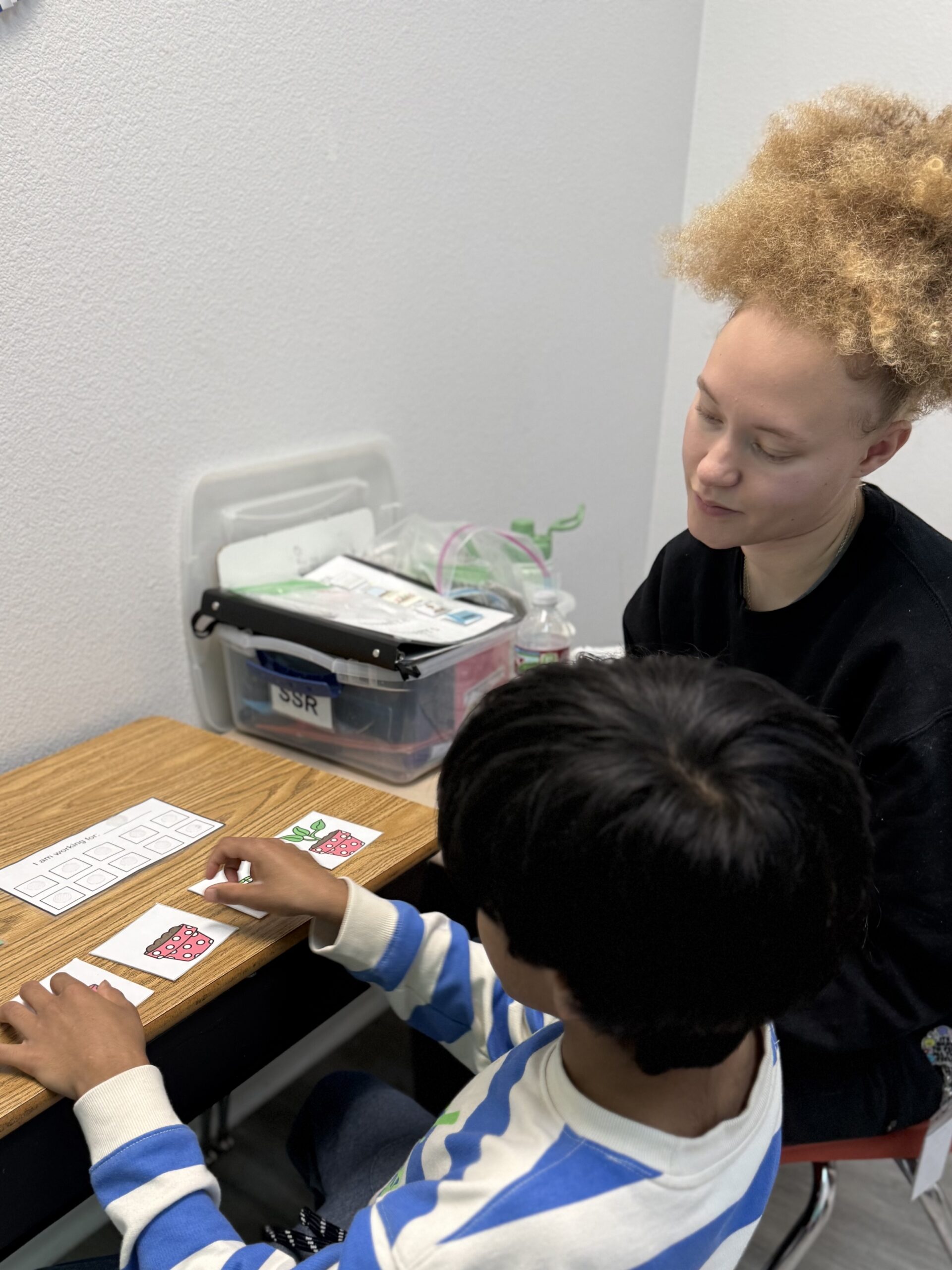 Teacher helping student with card activity.